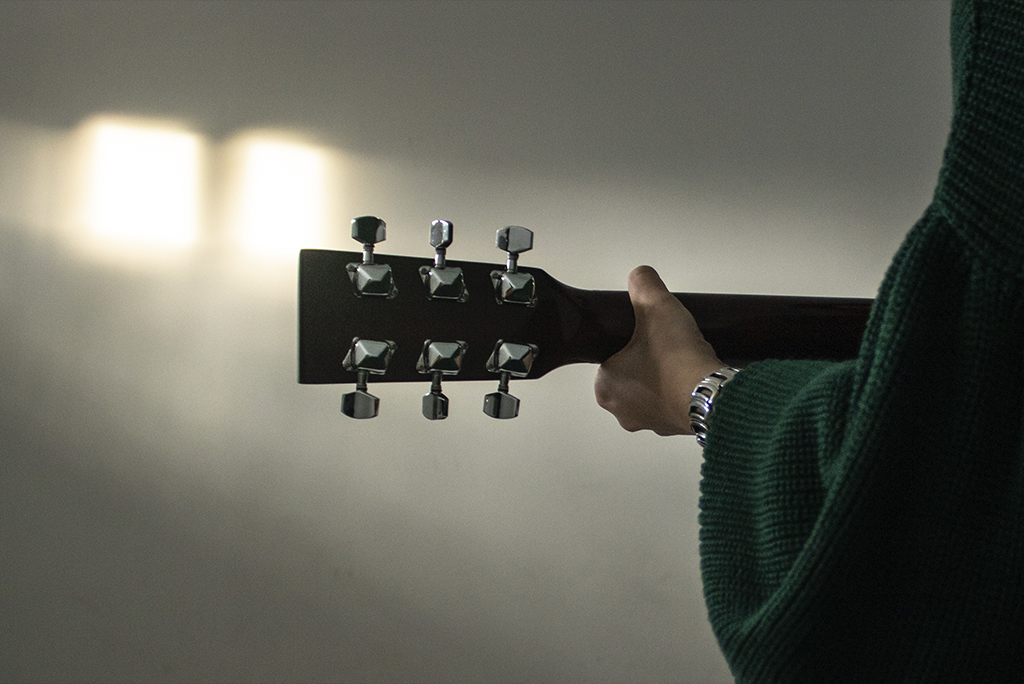 Fotografía detalle de la guitarra y la guitarrista con un estilo tradicional