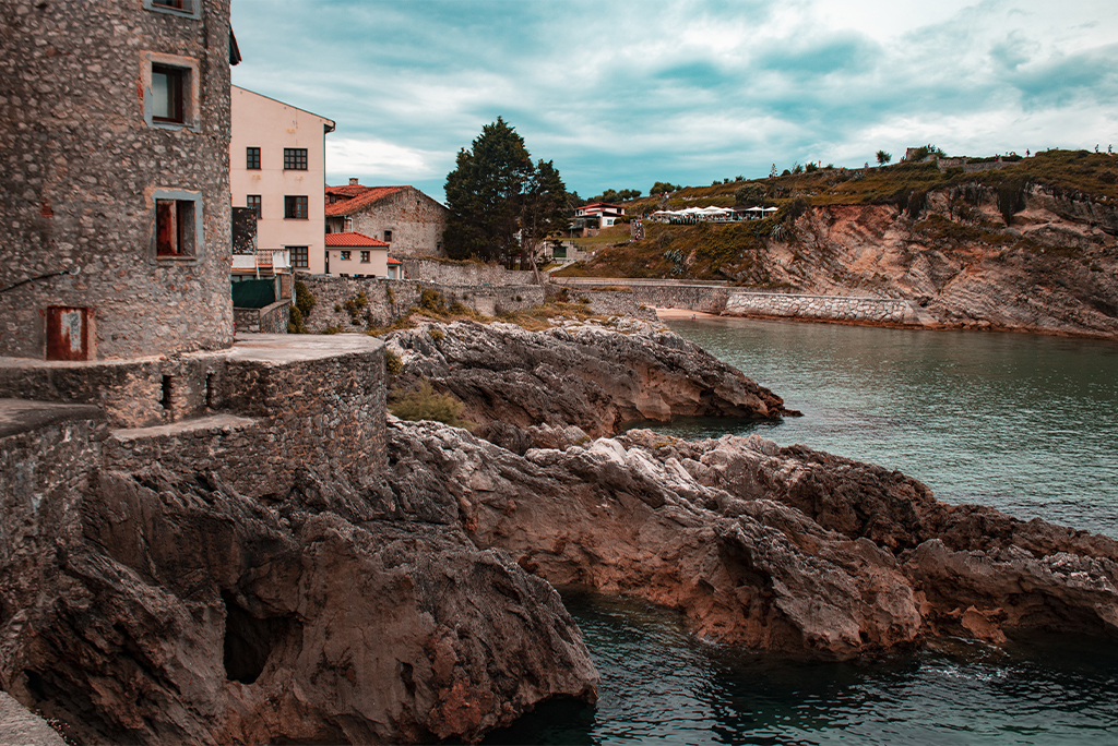 Fotografía de un paisaje de una casa con rocas y agua