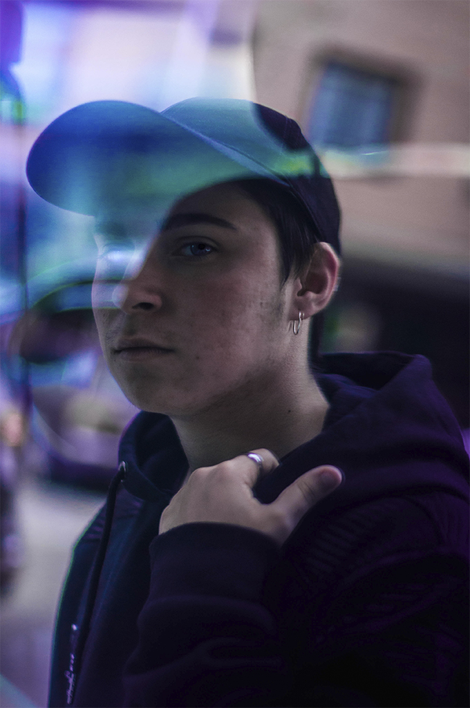 Fotografía retrato de un chico reflejado en un cristal con efectos de color